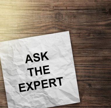 Kelimeler bir uzmana danışıyor. Tahta arka planda siyah kalemi olan beyaz bir kağıt. iş ve finans kavramı