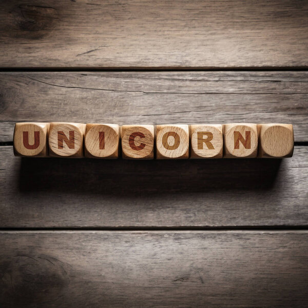 Алфавит единорога слово на деревянном блоке с деревянным фоном.