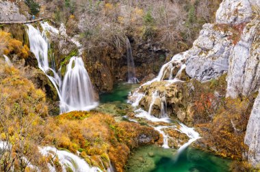 Renkli sonbaharda Plitvice Lakes Ulusal Parkı, Hırvatistan ve Avrupa. Sonbahar yaprakları ağaçların üzerinde. Şelaleler ve güneşli sabah ışığında sisli su. Manzara fotoğrafçılığı. Plitvicka Jezera Görünümü.