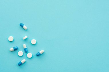 Pharmaceutical medicine tablets and stethoscope on a blue background. Face mask, surgical mask. The concept of medicine, hygiene and healthcare. Coronavirus. top view, copy space. 