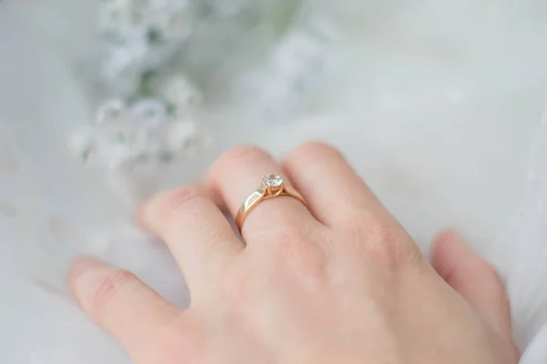 An elegant diamond ring on a woman\'s finger. The concept of love