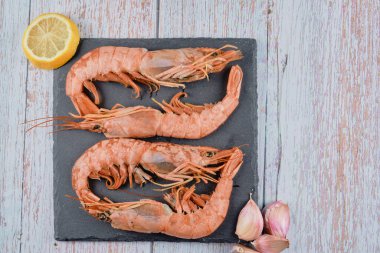 Yemek hazırlamak için çiğ karidesleri limon ve sarımsakla kapayın.