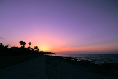 Sahil şeridi silueti. Gün batımı. Menekşe turuncu renkler.