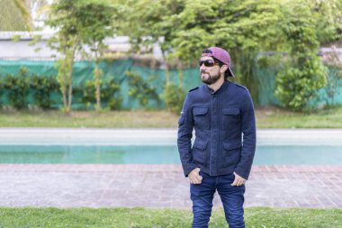 Havuz başında dikilen Latin bir adamın portresi.