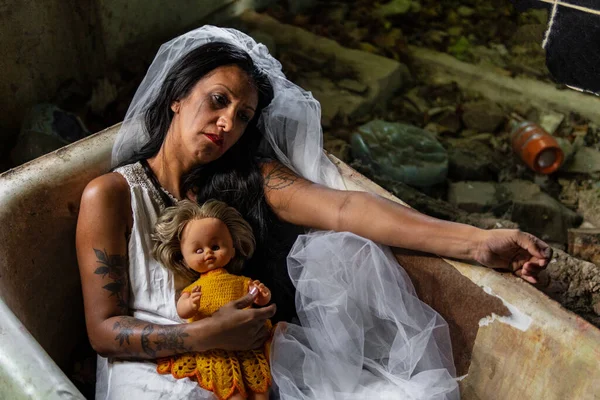 Stock image Deranged bride with a doll in a bathtub. Inspired by the traditional American legend of la llorona (the weeping woman)