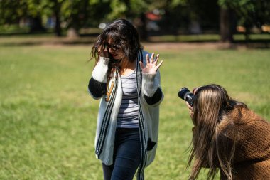 Paparazzileri reddeden bir kadın. Fotoğrafçı, reddeden kişinin fotoğrafını çekmeye çalışıyor.