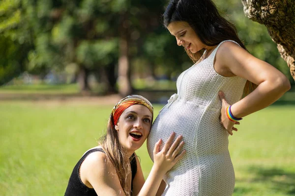 Genç Kadın Güzel Hamile Kız Arkadaşının Karnını Dinliyor Gülümsüyor — Stok fotoğraf