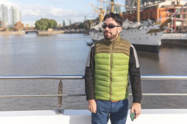 Porto Madero, Buenos Aires, Arjantin 'de bir teknenin önünde poz veren mutlu bir turist.