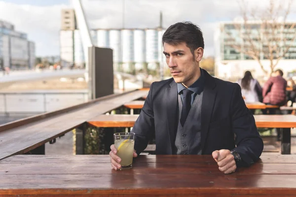 Adamı Açık Hava Barında Oturmuş Limonata Içiyor Kameraya Bakıyor — Stok fotoğraf