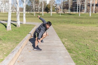 Genç adam parkta Kung Fu çalışıyor.