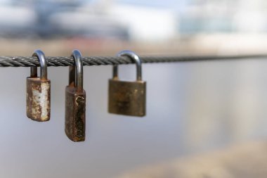 Köprü parmaklıklarında asılı eski paslı asma kilitler. 