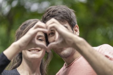 El ele tutuşup kalp yapan bir çift.