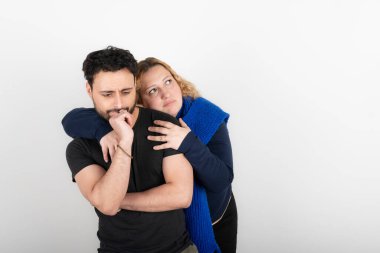 Kadın ortağına arkadan sarılıyor. İkisi de kayıp bir bakış ve düşünceli bir ifadeyle..