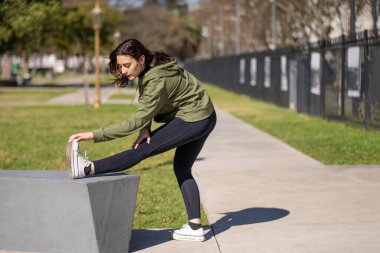 Genç bir kadın esneme egzersizi yapıyor.