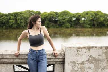 Rıhtımda duran genç bir kadın kayıp bir bakışla yana bakıyor.