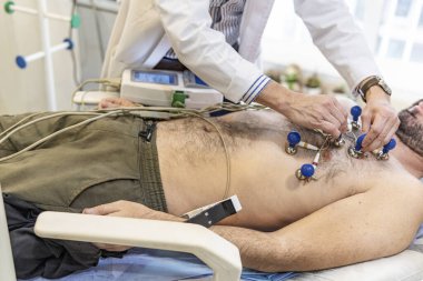 Hasta kardiyolojik muayeneden geçiyor. Doktor elektrokardiyogram yapıyor.