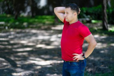 Parkta rahat poz veren çekici Latin adam.