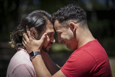 Parkta kafa kafaya verip birbirine sarılan iki Latin adam.