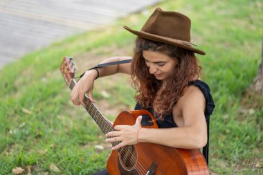 Gitarını akort eden kadın gitarist.