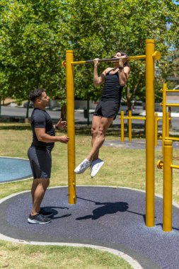 Arkadaşı onu izlerken adam parkta barfiks çekiyor.