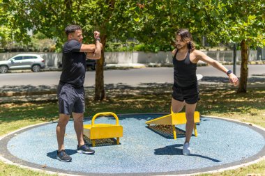 Genç ve zinde Latin erkekler parkta esneklik egzersizleri yapıyor.