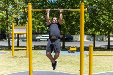 Parkta barfiks çeken genç bir adam.