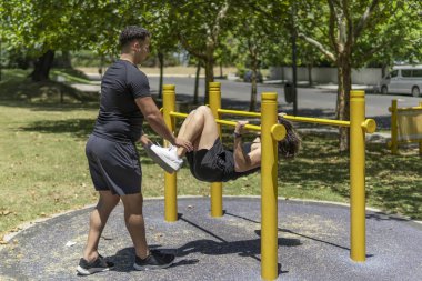 Parktaki paralel çubuklarda egzersiz yapan Latin erkekler