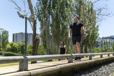 Parkta koşmaya başlayan iki Latin adam.