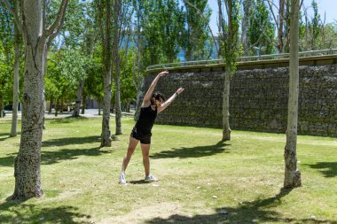 Genç Latin bir adam parkta modern dans yapıyor.