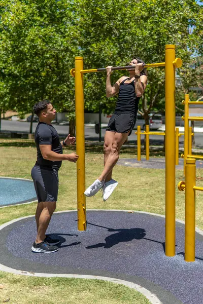 Arkadaşı onu izlerken adam parkta barfiks çekiyor.