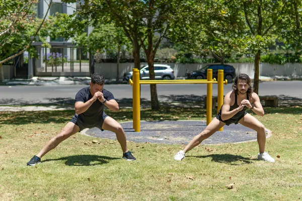 Genç Latin erkekler esneme egzersizi yapıyor.