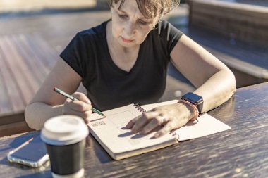 Dışarıdaki notlarına bakan kıdemli kadın.