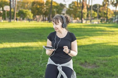Olgun bir kadın dans ve müzik eşliğinde kendini ifade ediyor.