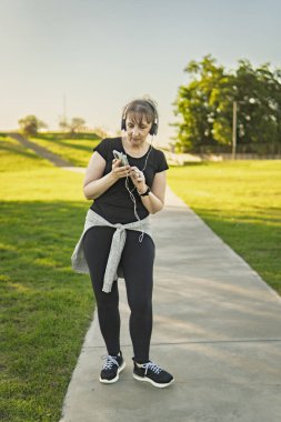 Dışarıda kulaklıkla dans eden olgun bir kadın.