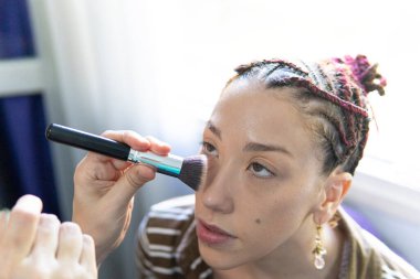 Şekil verme sanatı: bir modelin yanağında makyaj fırçası