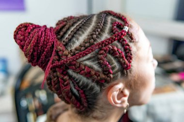 Afrika örgü sanatının ayrıntılı görünümü karmaşık bir updo ve karışık renkler içeriyor