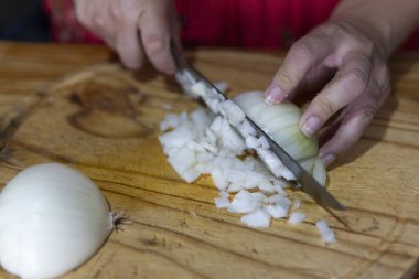 Ellerin ustalıkla bir soğanı dilimliyor.