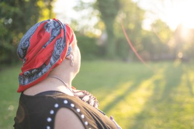 Portrait of a female cancer survivor holding a rosary at sunset