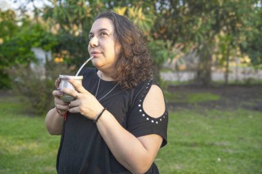 Woman savoring the traditional south american mate beverage