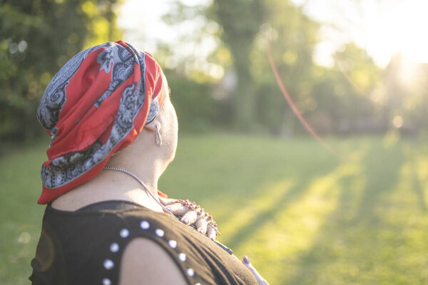 Portrait of a female cancer survivor holding a rosary at sunset