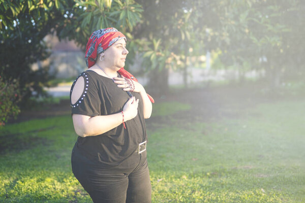 Emotional portrait of a female survivor embracing hope and spirituality outdoors