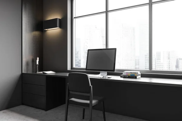 Dark home office interior with pc computer and armchair, side view. Drawer with minimalist decoration in the corner. Panoramic window on skyscrapers. 3D rendering