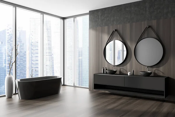 Corner view on dark bathroom interior with bathtub, two round mirrors, double sink, panoramic window with Singapore view, wooden walls, oak hardwood floor. Concept of modern design. 3d rendering