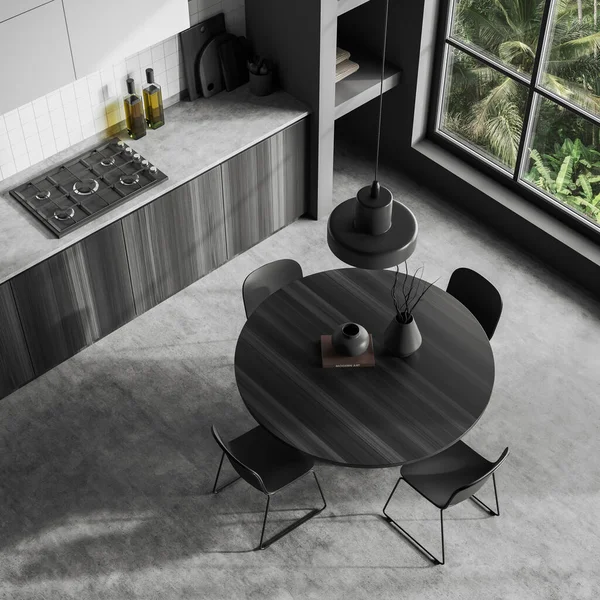 Top view of dark kitchen interior with dining table and chairs, grey concrete floor. Cooking and eating corner with panoramic window on tropics. 3D rendering