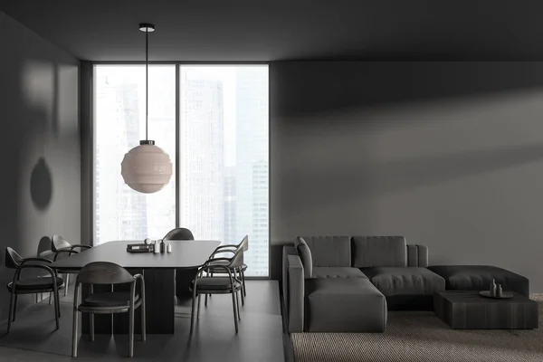Dark living room interior with dining table and chairs on podium, grey concrete floor. Sofa and coffee table near panoramic window on skyscrapers. Mockup empty wall. 3D rendering