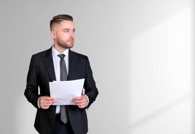 Rüyasında takım elbiseli yakışıklı bir iş adamı arka planda boş beyaz duvarın yanında notlar tutuyor. Model kavramı, düşünceli iş adamı, düşünülen adam, avukat, sözleşme