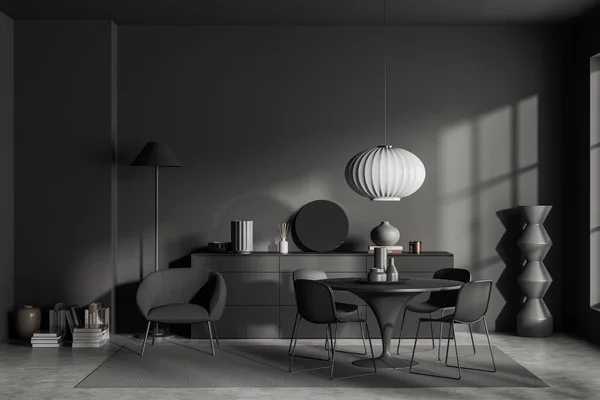 Dark living room interior with round table and chairs, armchair with lamp on carpet on grey concrete floor. Relaxing area and sideboard with minimalist decor. 3D rendering
