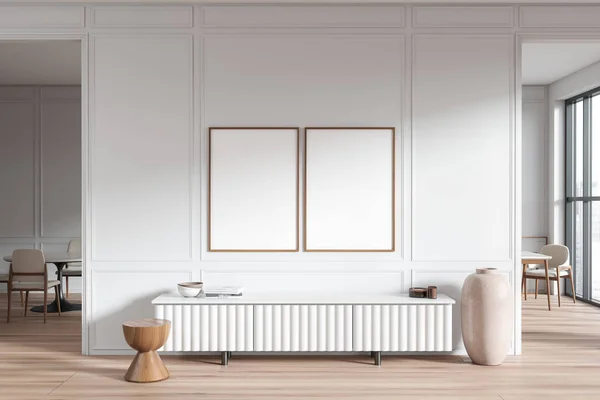 White living room interior with sideboard on hardwood floor. Dining table and chairs on background, arch door and panoramic window. Two mockup canvas posters. 3D rendering