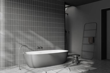 Dark bathroom interior with bathtub and carpet on grey concrete floor. Bathing corner with stool and towel rail ladder. Copy space tile wall. 3D rendering