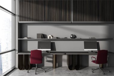 Dark coworking interior with pc computer on desk, armchairs on grey concrete floor. Shelf with decoration and panoramic window on skyscrapers. 3D rendering